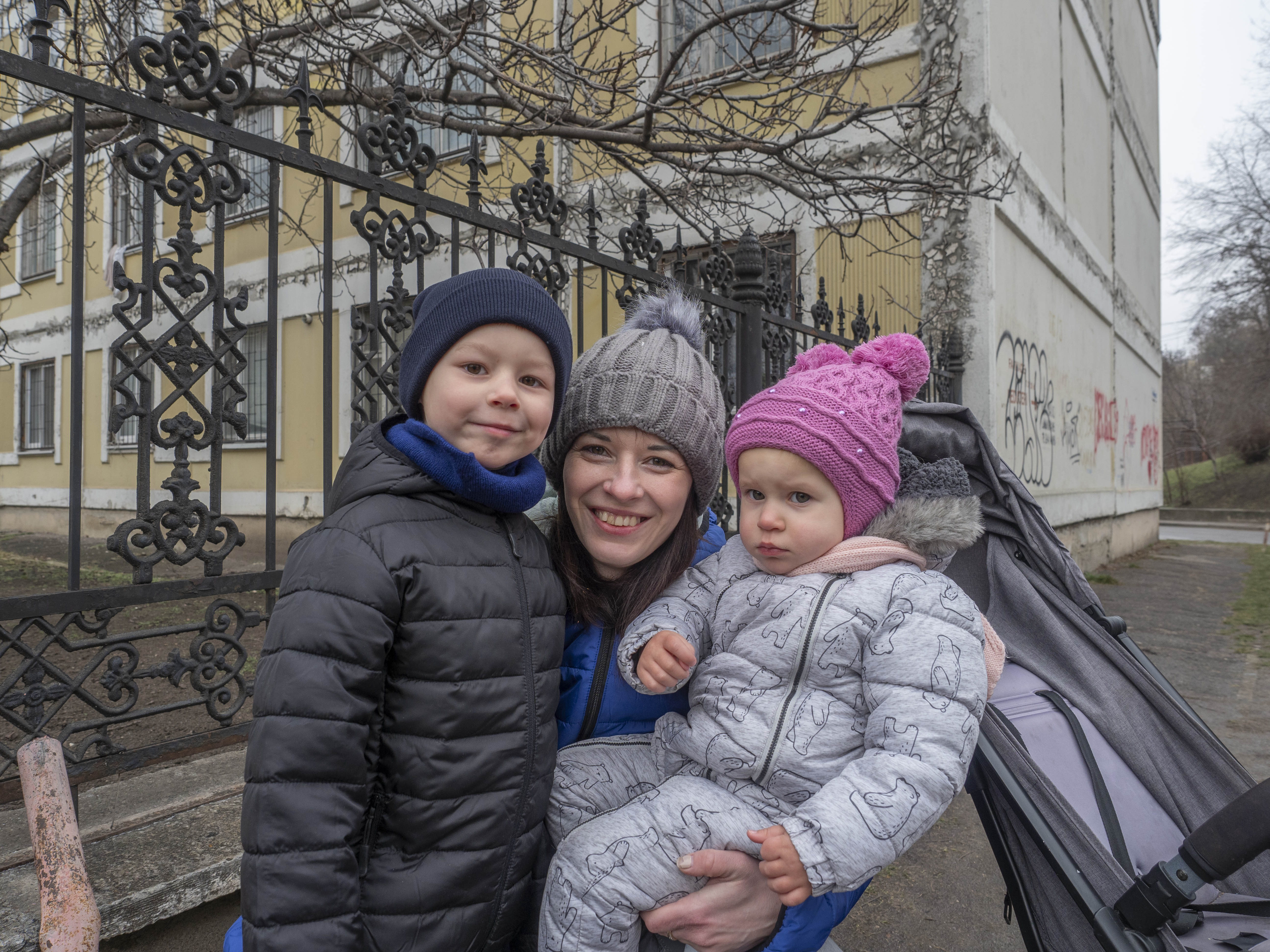 Olena, flykting i Moldavien från Ukraina, med sina två barn under fem år. De är fotograferade utomhus iklädda vinterkläder.
